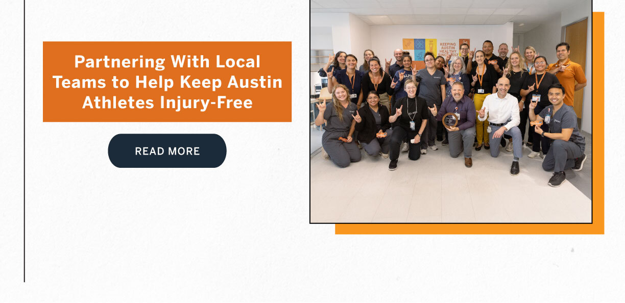 Large group of smiling healthcare staff pose together in a clinical setting, many holding up Hook 'em hand signs, celebrating partnerships that support Austin athletes.