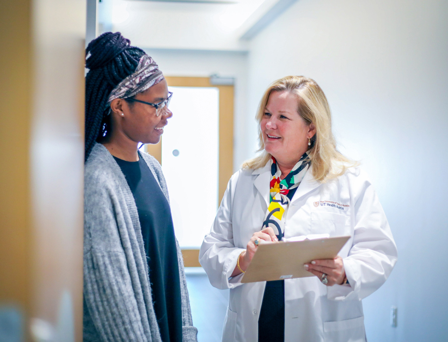 Amy Young, MD, speaking to a patient in a hallway.
