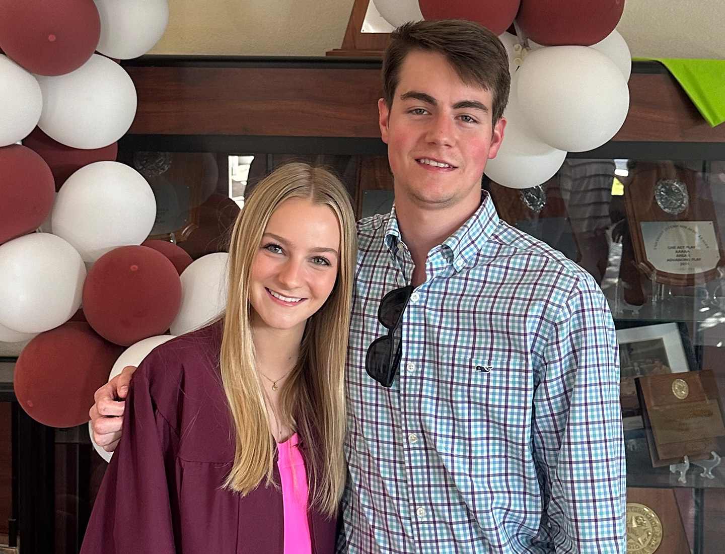 Cole Perry posing with a friend in front of a balloon arch.