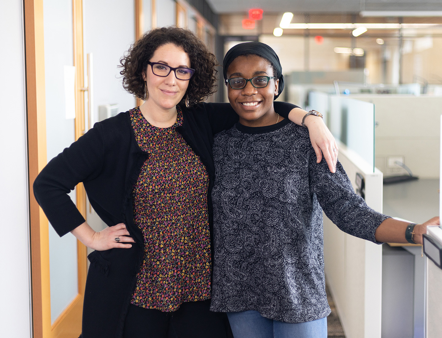 Dr. Leorah Freeman and Helen Onuorah are smiling and standing arm in arm in their lab.