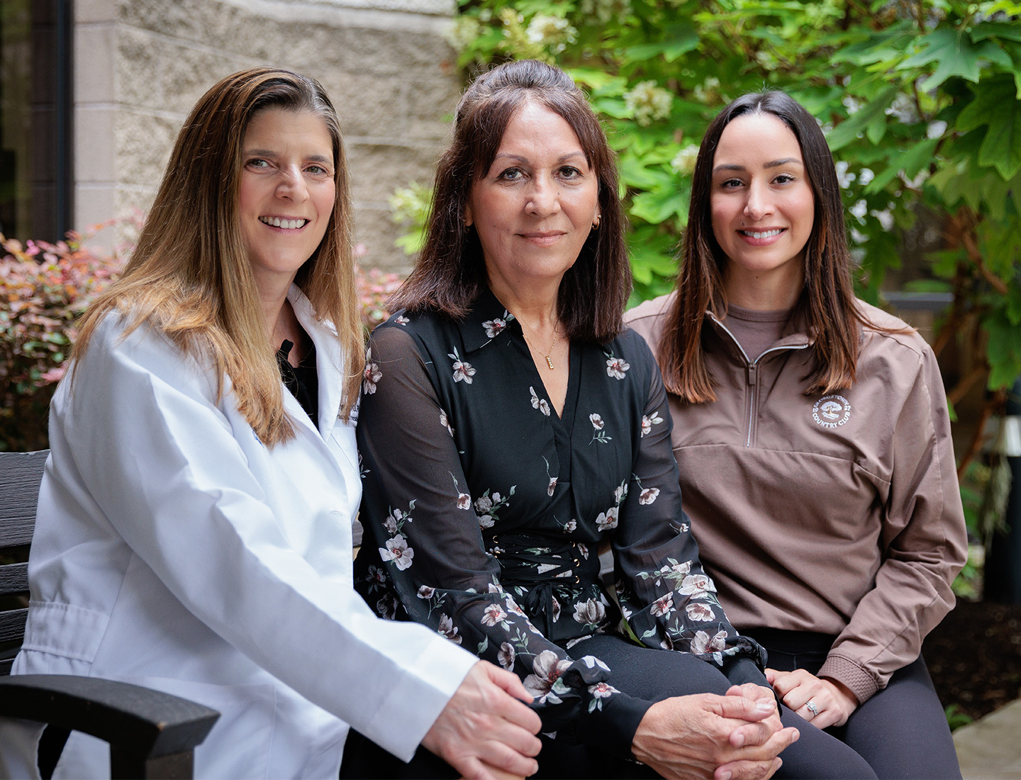 Nicole Turgeon, MD, FACS, posing outdoors with patient Julie and her daughter Kelli.