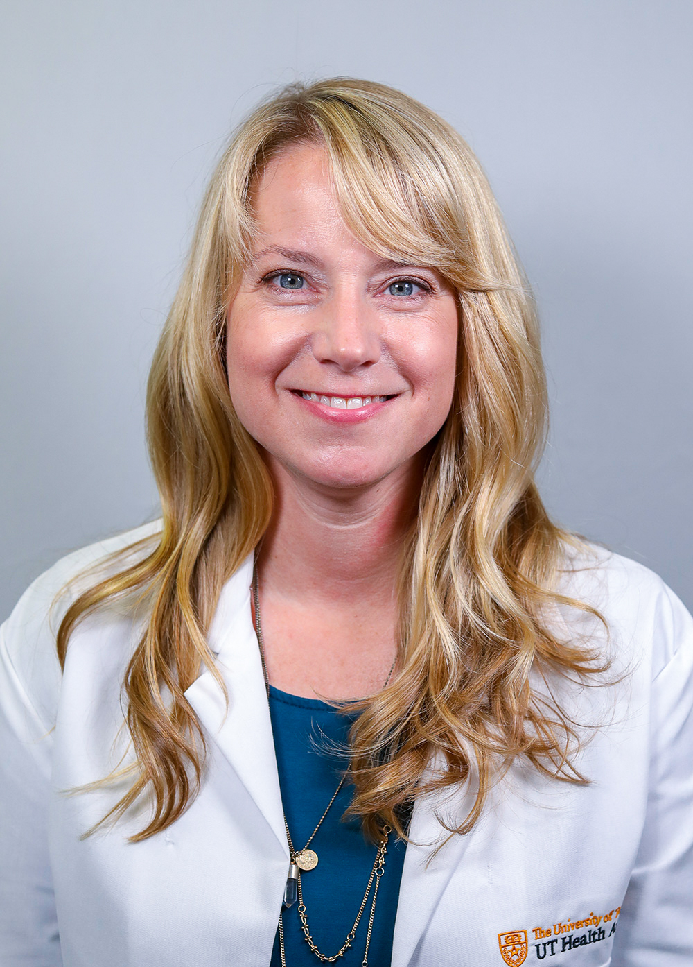 Pediatric nurse practitioner Janet Wilson MSN, CPNP-PC, wearing a white coat and smiling in front of a white backdrop.