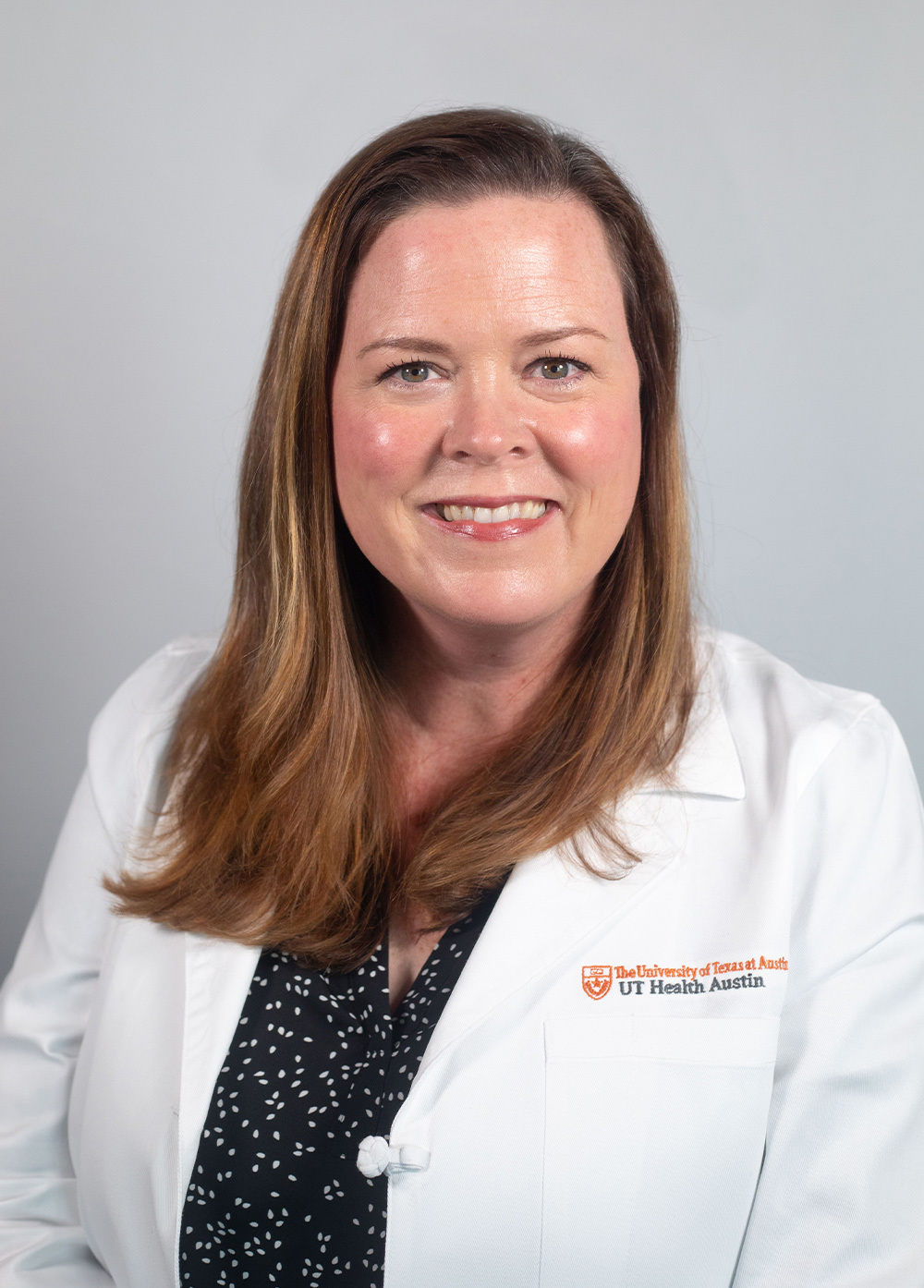 Acute care pediatric nurse practitioner Molly Trexler, APRN, CPNP-AC/PC, wearing a white coat and smiling in front of a white backdrop.