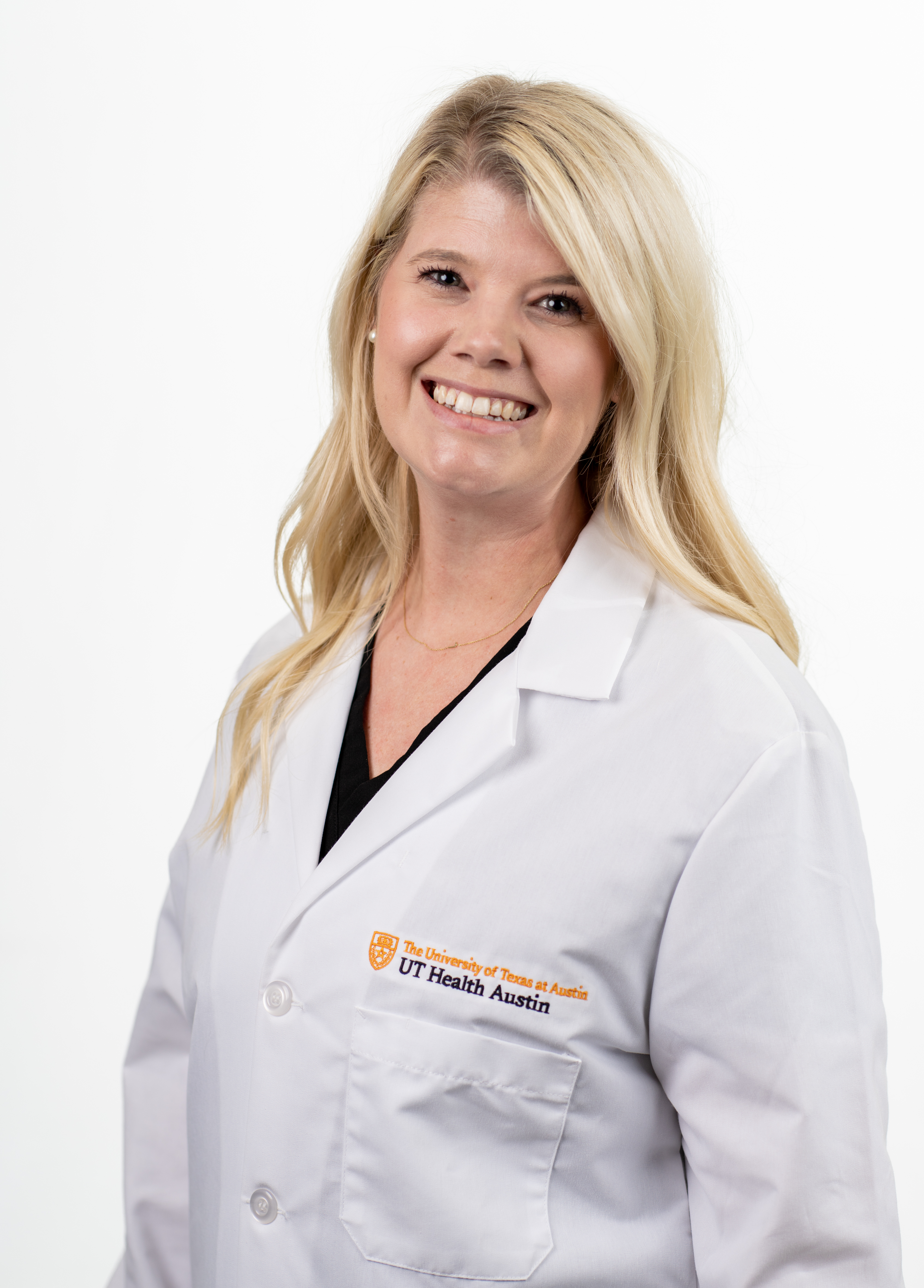 Amber Matthews, MSN, APRN, CPNP-AC, wearing a white coat and smiling in front of a white background.