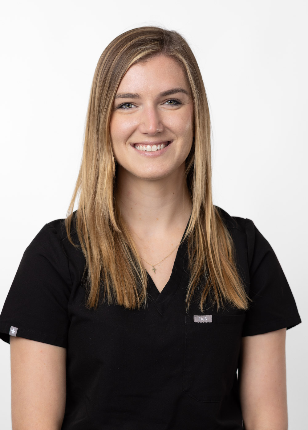 Ann Rea is smiling at the camera. She is wearing black scrubs.
