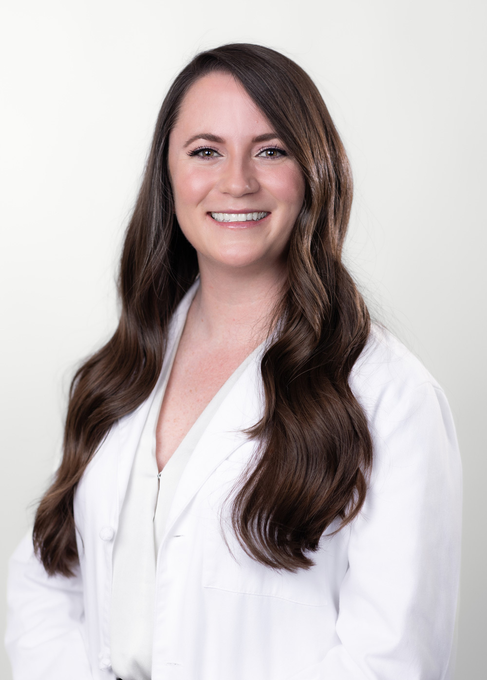 Headshot of Ashleigh Noble. She is wearing a white blouse and a white coat.