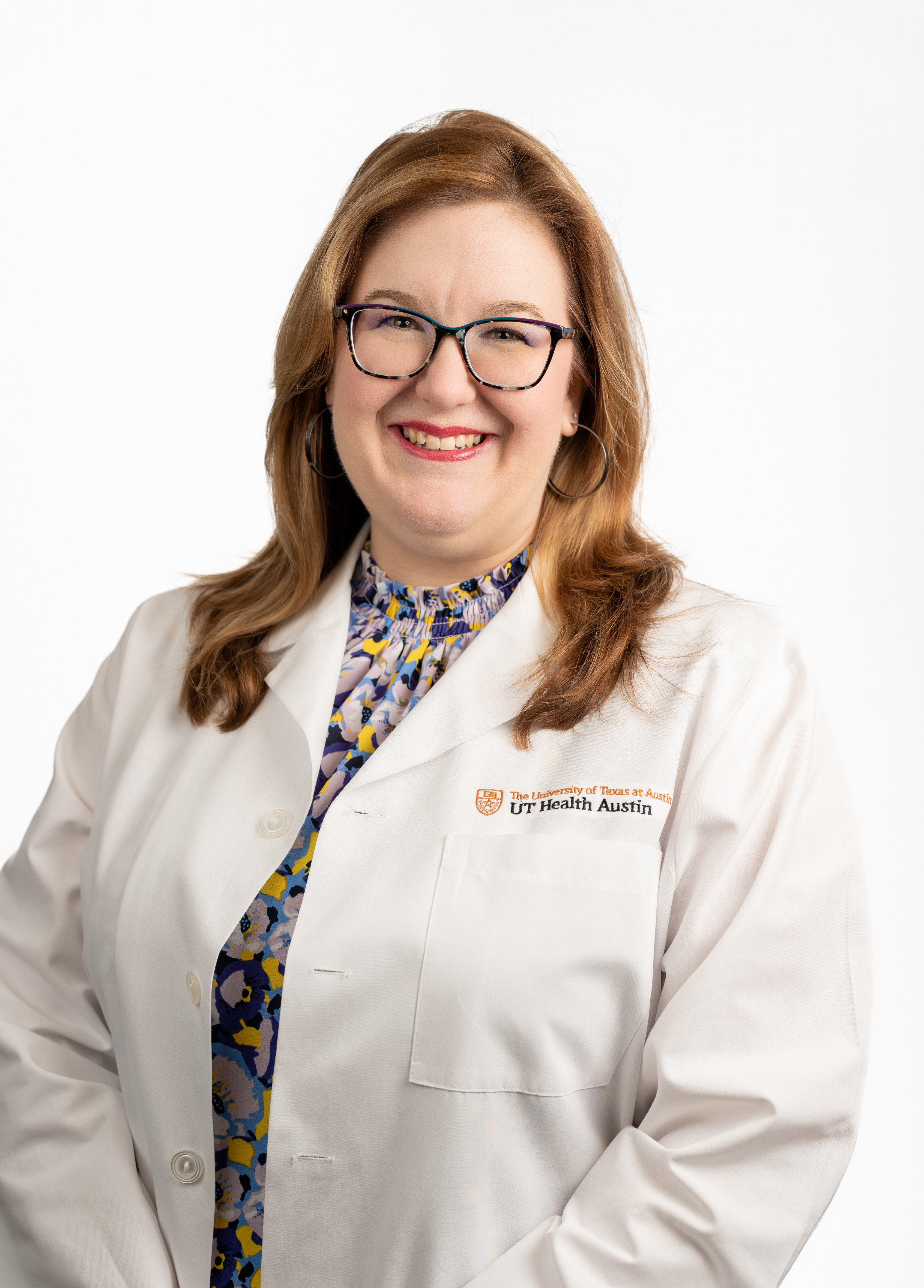 Dr. Ashley Stanley-Copeland wearing a white coat and smiling in front of a white backdrop.