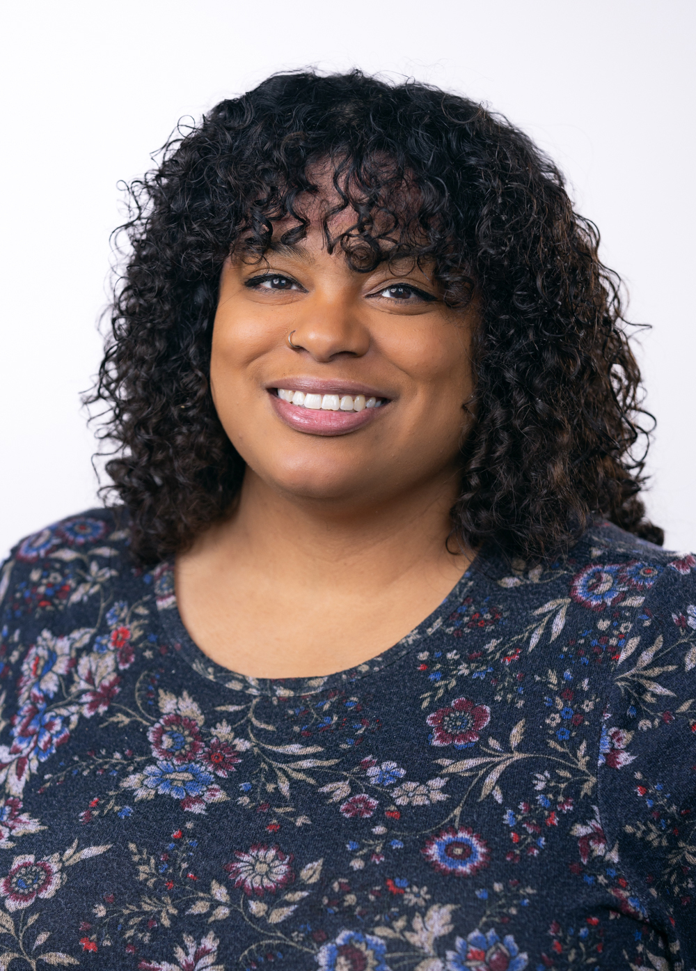Camille Clark, LPC, smiling and looking at the camera and standing against a white background.