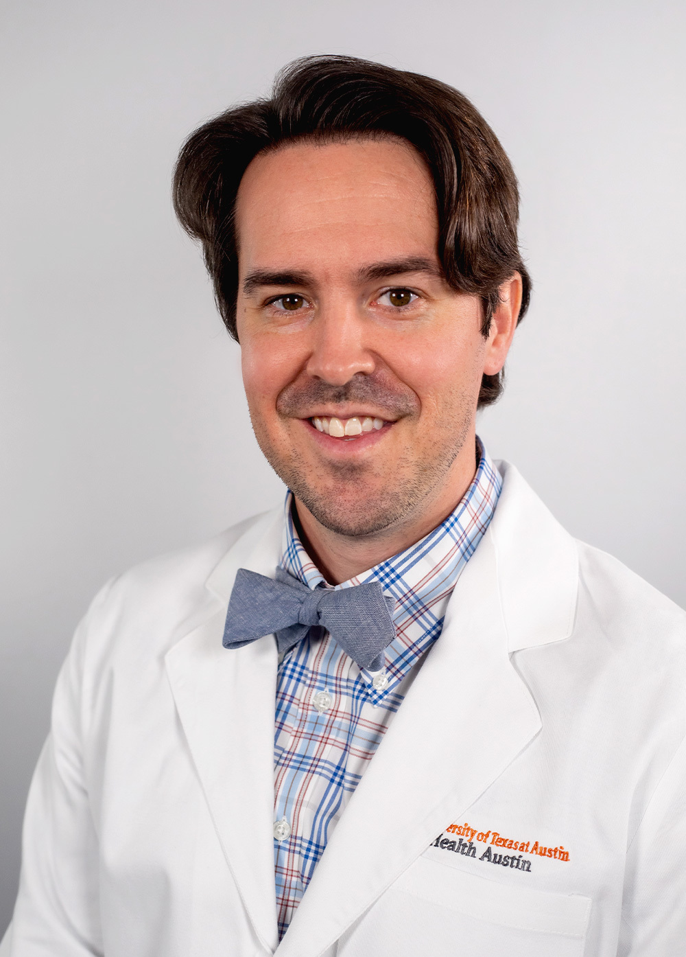 Pediatric neurologist Clifford Calley, MD, wearing a white coat and smiling in front of a white backdrop.
