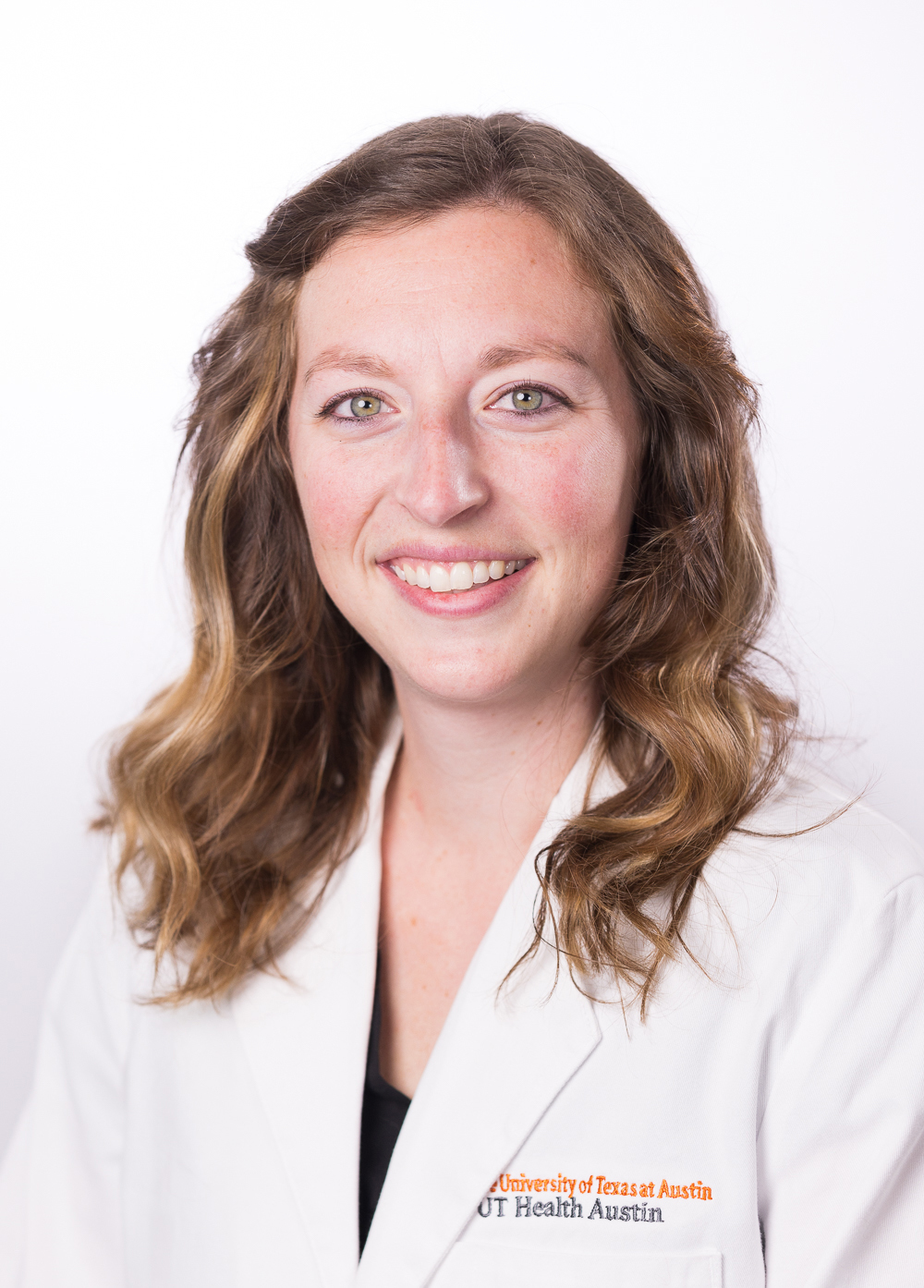 Acute care pediatric nurse practitioner Lauren Westin, APRN, wearing a white coat and smiling in front of a white backdrop.