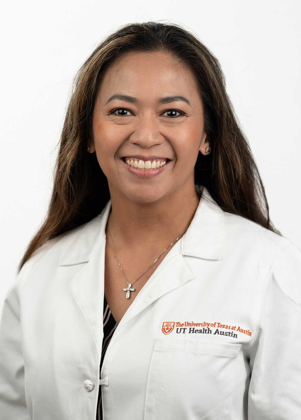 Physician assistant Marie Listchewski, smiling in front of a white backdrop. She is wearing a white coat with an embroidered UT Health Austin logo.