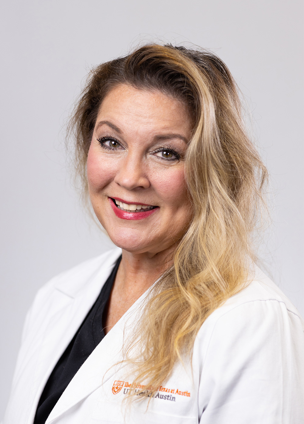 Acute care pediatric nurse practitioner Rebecca Byars MSN, RN, APRN, CPNP-AC/PC, wearing a white coat and smiling in front of a white backdrop.