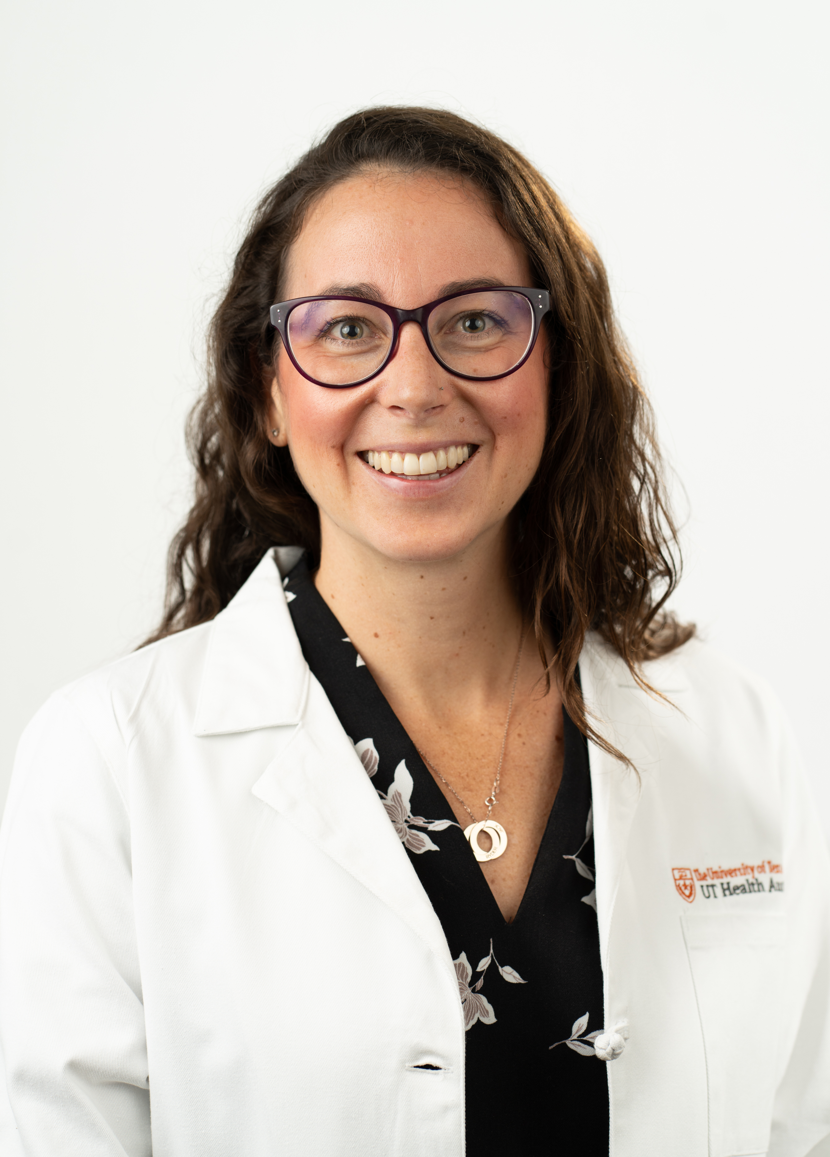 Samantha Irwin, pediatric neuroscience specialist stands in front of a white background smiling.