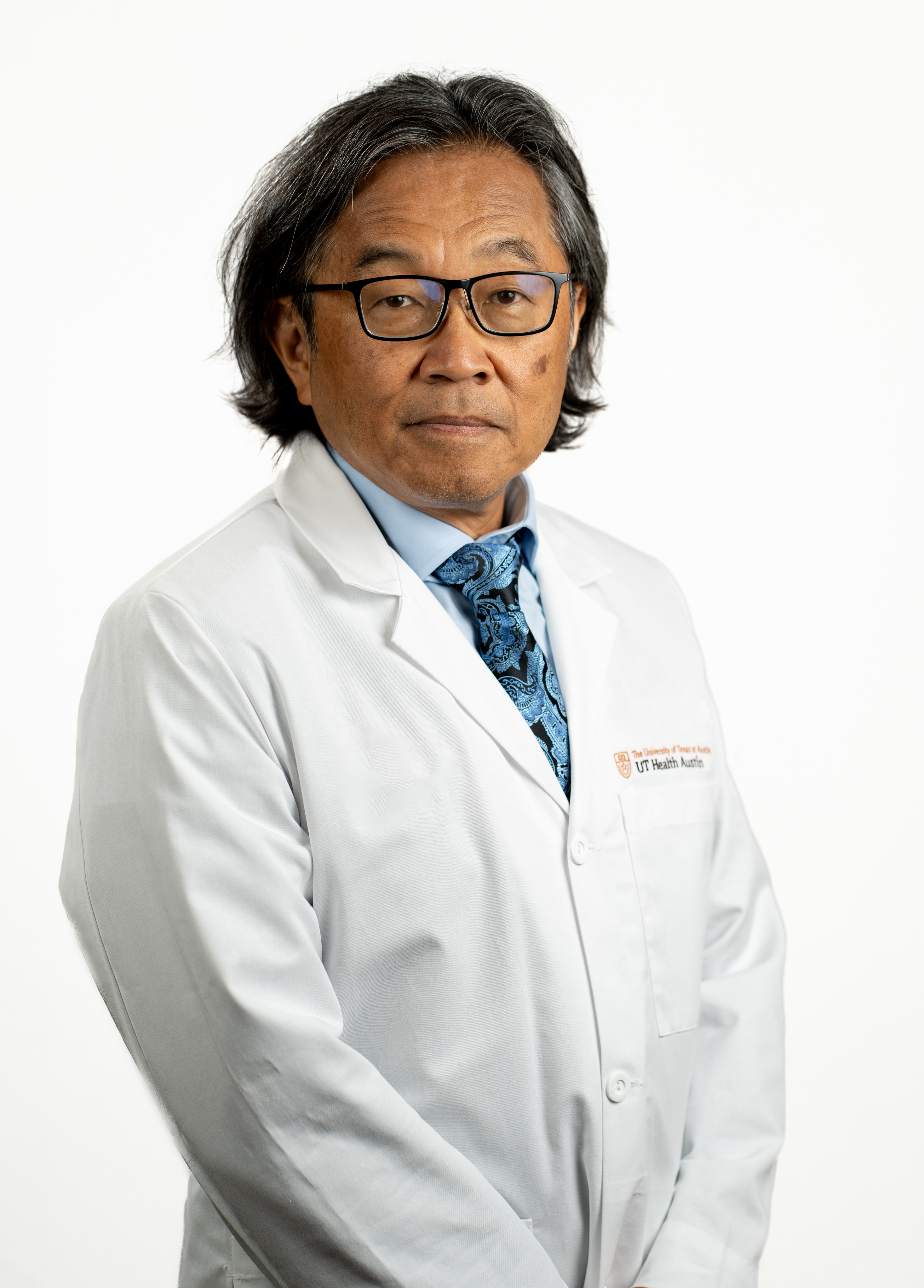 Cardiothoracic surgeon Satoshi Furukawa, MD, wearing a white coat and posing in front of a white backdrop.