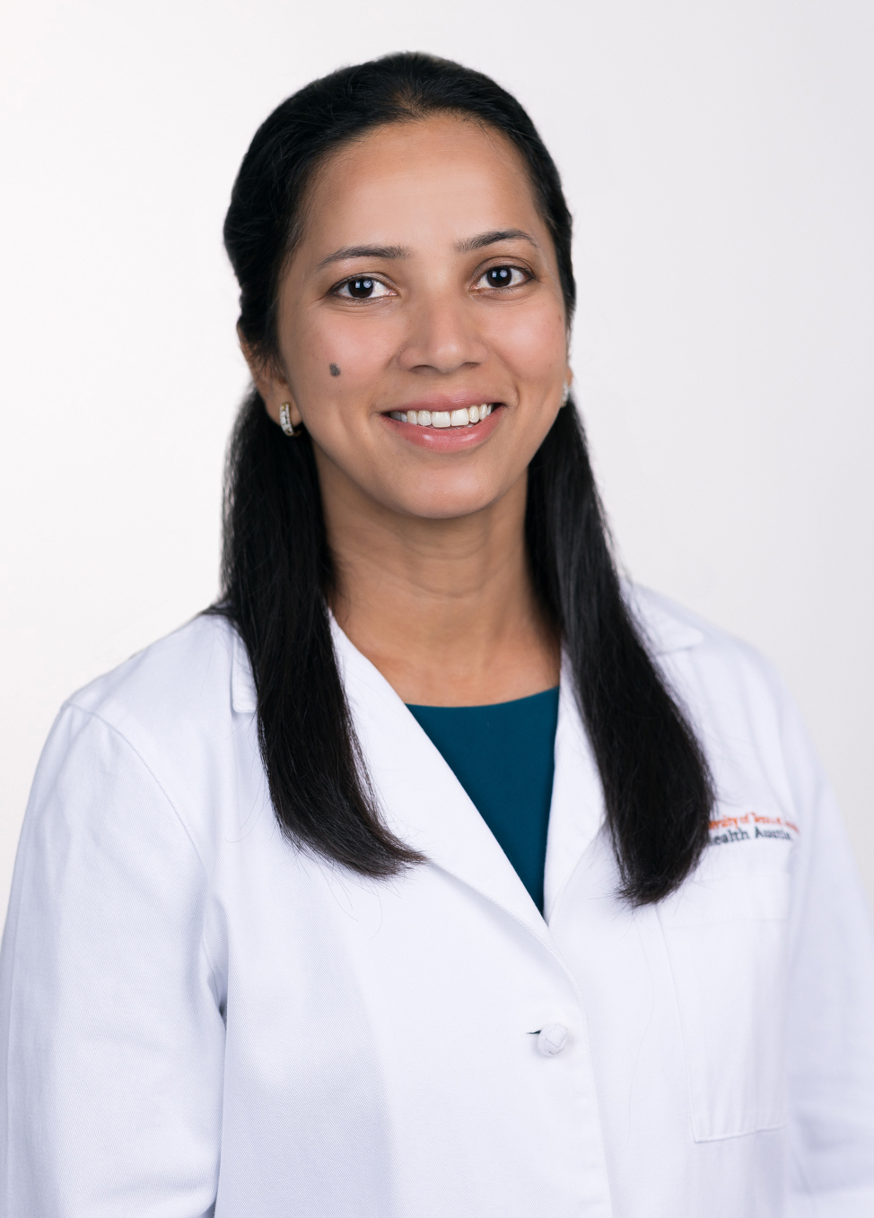 Dr. Sowmya Boddhula is smiling at the camera. She is wearing a white coat and a turquoise blouse.
